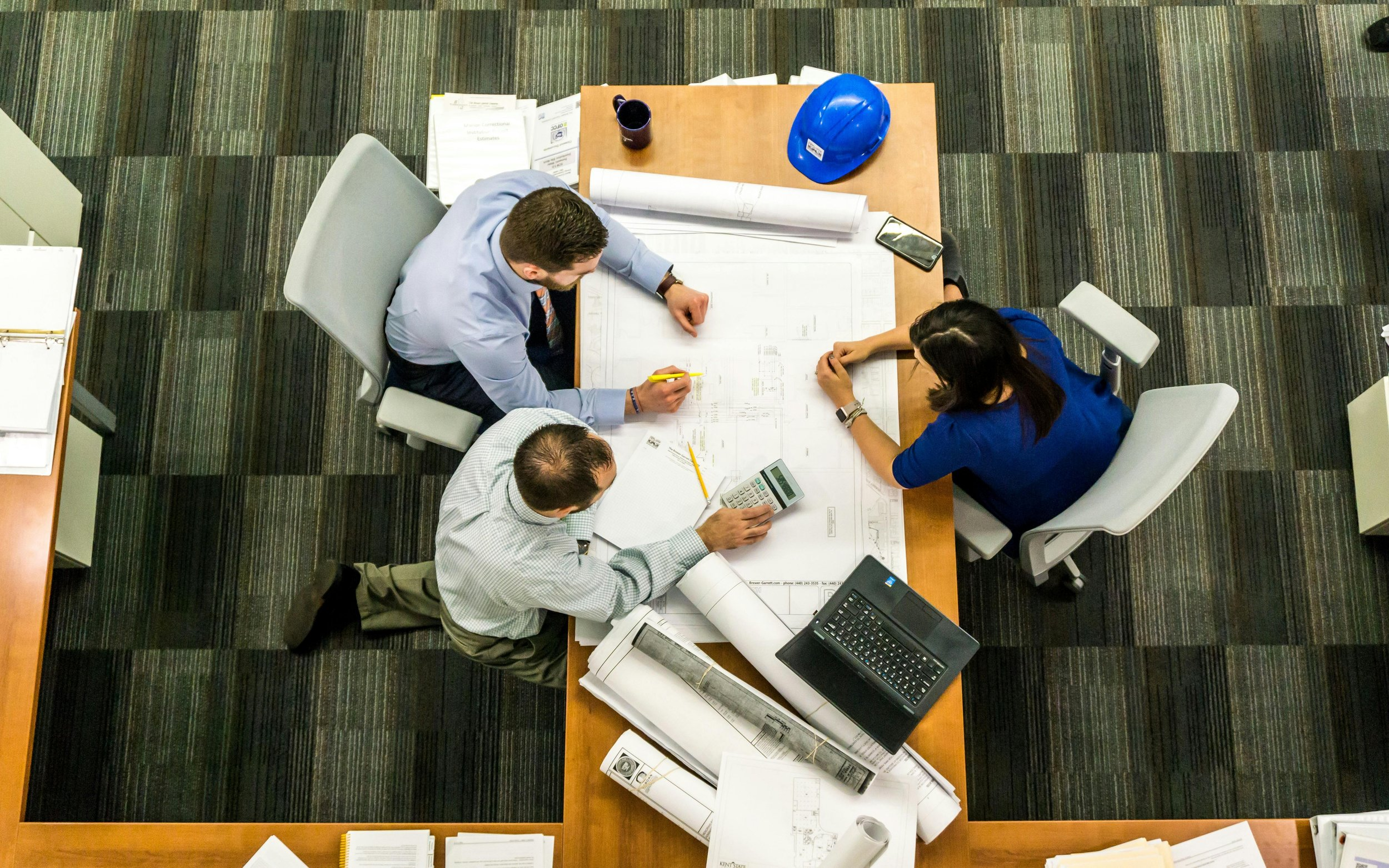 Construction workers reviewing plans on a build site.
